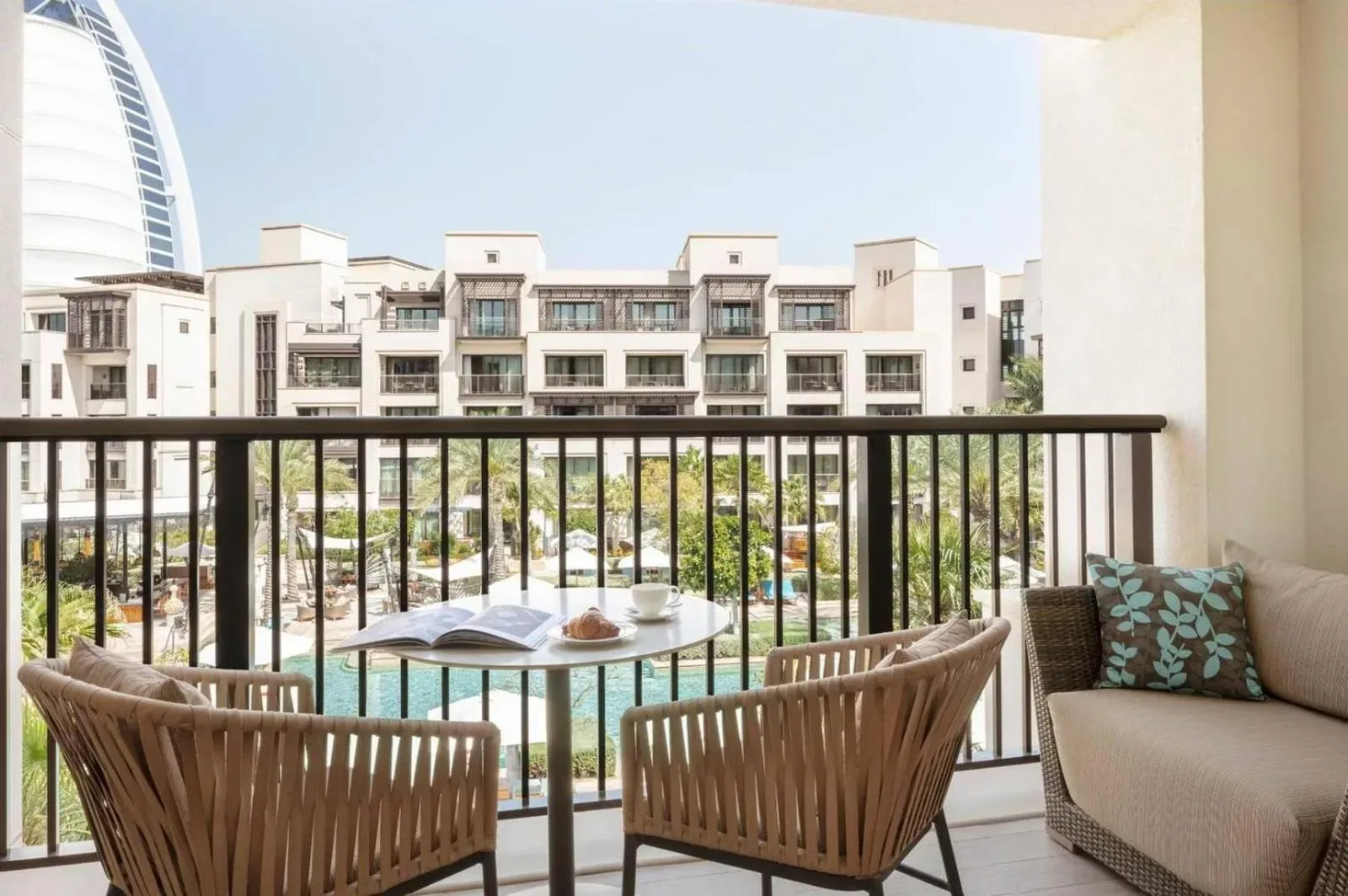Jumeirah Al Naseem Dubai – Dubai, United Arab Emirates hotel – a balcony with a table and chairs and a building at Jumeirah Al Naseem Dubai in Dubai