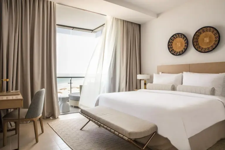 Jumeirah Saadiyat Island Abu Dhabi – Hotel in Abu Dhabi, Vereinigte Arabische Emirate – ein Schlafzimmer mit einem Bett, einem Schreibtisch und einem Fenster im Jumeirah Saadiyat Island Abu Dhabi in Abu Dhabi