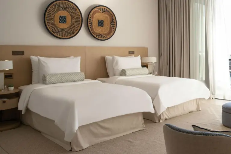 Jumeirah Saadiyat Island Abu Dhabi – Hotel in Abu Dhabi, Vereinigte Arabische Emirate – ein Hotelzimmer mit zwei Betten und zwei Spiegeln im Jumeirah Saadiyat Island Abu Dhabi in Abu Dhabi