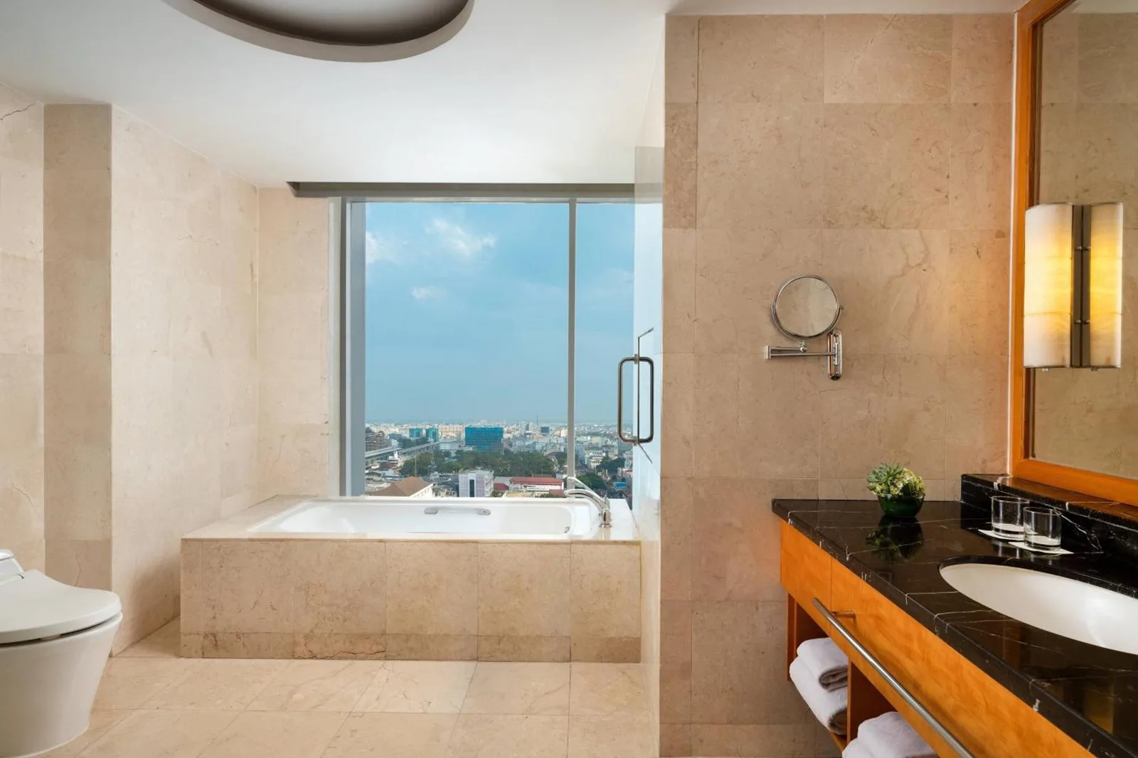 Salle de bains moderne avec vue sur la ville au JW Marriott Hotel Medan