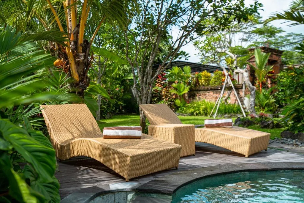 Chaises longues à Kak Oman By Madhava Villas près de la piscine
