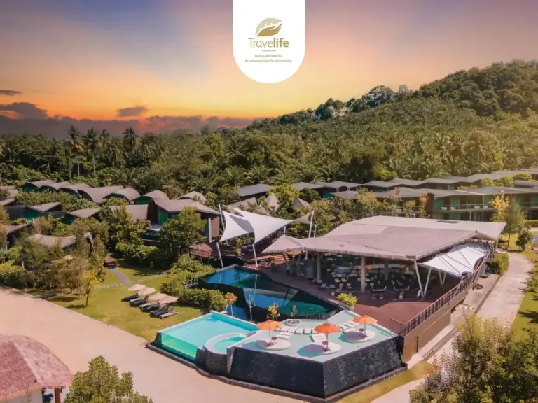 Aerial view of Kalima Resort and Villas Khao Lak with pools, villas, and sunset mountain scenery in Khao Lak, Thailand.