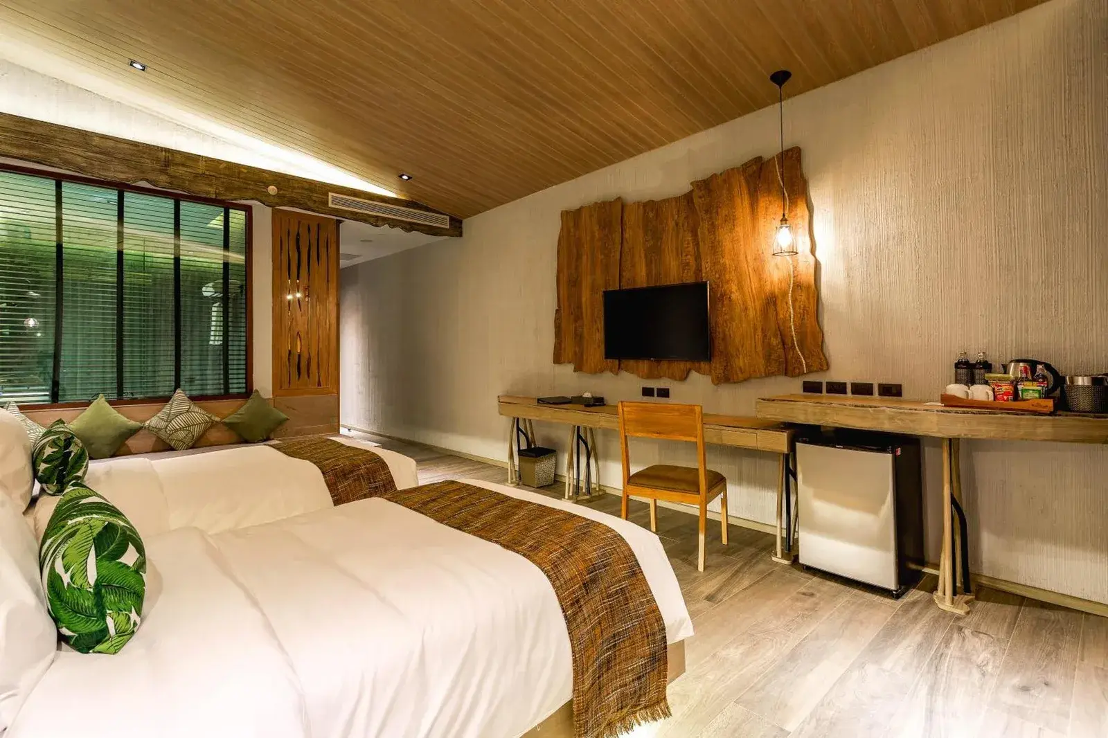 Twin room at Kalima Resort and Villas Khao Lak with desk, TV, and wood-themed interior in Khao Lak.