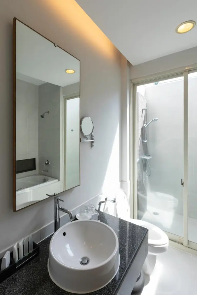 Baño en Kantary Beach Hotel Villas & Suites en Khao Lak con lavabo, espejo, ducha e inodoro