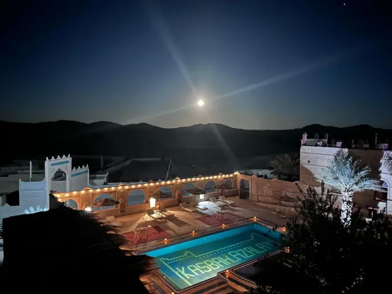 Night view of the pool at Kasbah Azalay Merzouga under the moonlight