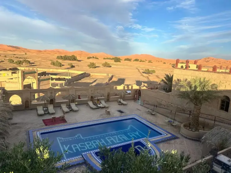View of the pool at Kasbah Azalay Merzouga with desert backdrop