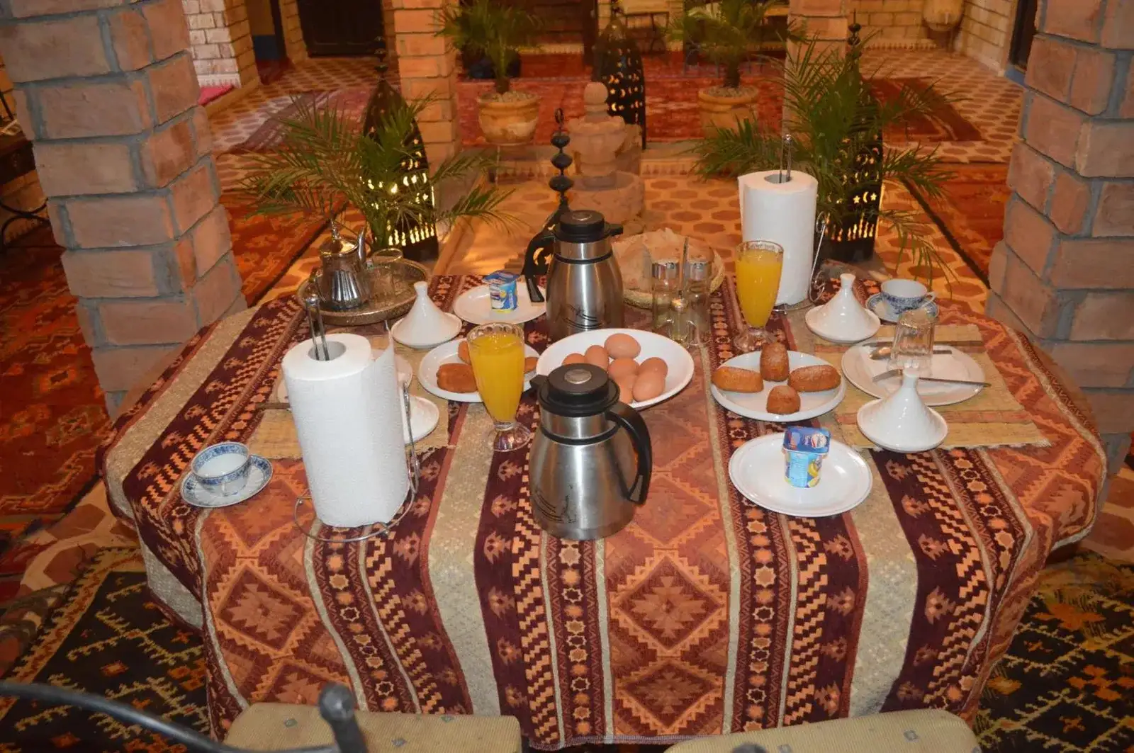 Table de petit-déjeuner au Kasbah Planet Sahara hotel à Merzouga avec thé, jus et viennoiseries