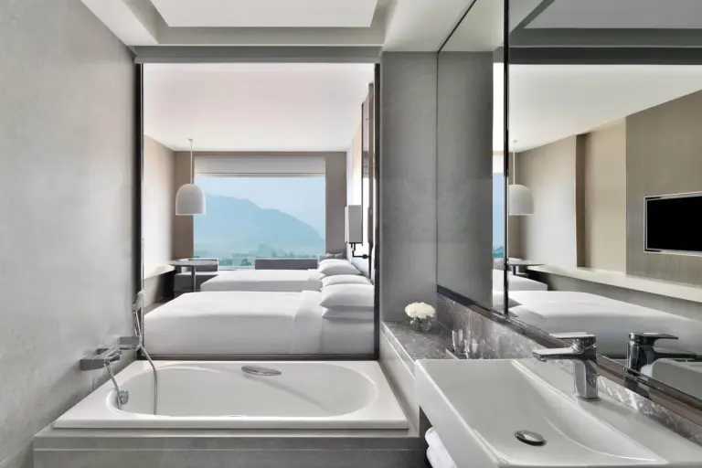 Badezimmer- und Zimmeransicht im Deluxe King Room im Kathmandu Marriott Hotel.