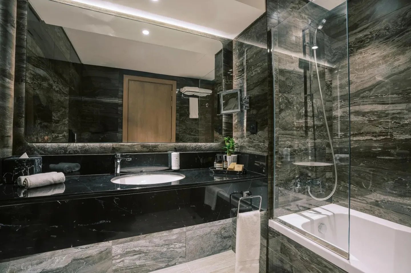 Modernes Badezimmer im Khalidia Palace Hotel Dubai mit dunklen Steinoberflächen, Waschbecken, Toilette und Bidet