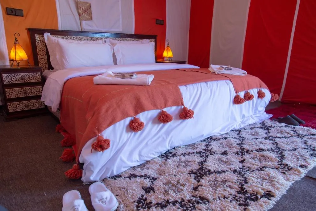 Orange bed tent at Khamlia Desert Camp in Merzouga