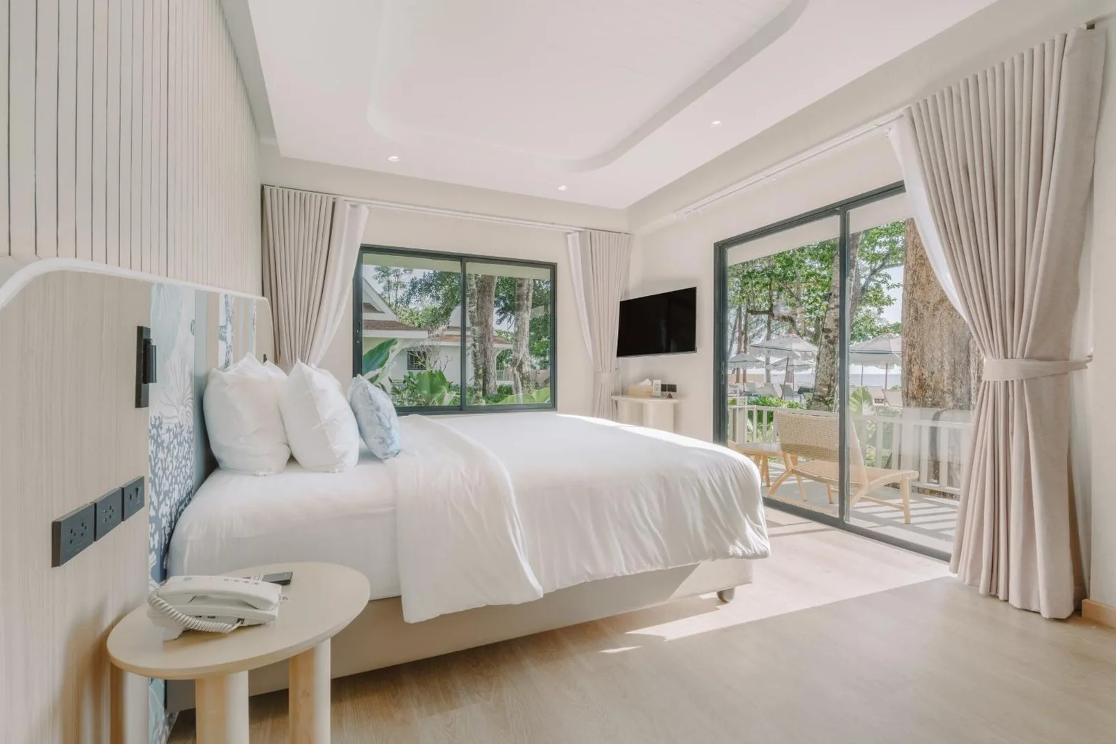 Elegante dormitorio de villa en Khaolak Emerald Beach Resort and Spa en Khao Lak, con vistas al jardín y terraza privada.