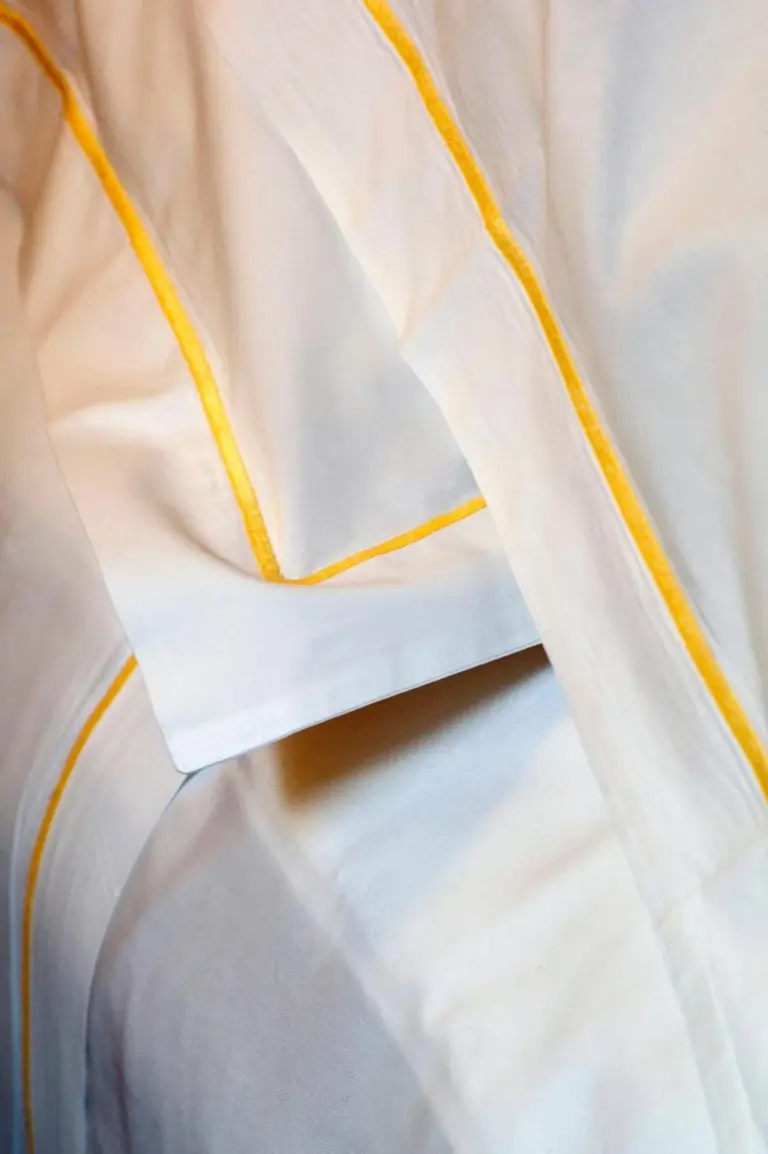 Gros plan de la literie à L'Hôtel à Beaune avec des textiles fins
