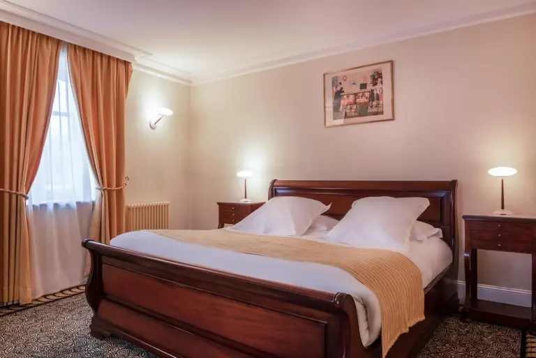 Lit douillet dans une chambre d'invité à L'Hôtel à Beaune