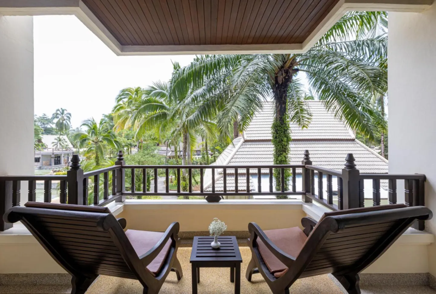 Vue depuis le balcon d'une chambre à La Solaya Khao Lak entourée de palmiers