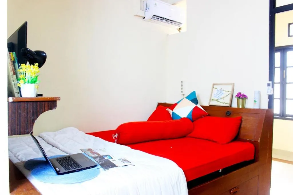 Cozy bedroom at Lagura Residence in Jakarta with red decor and a work desk