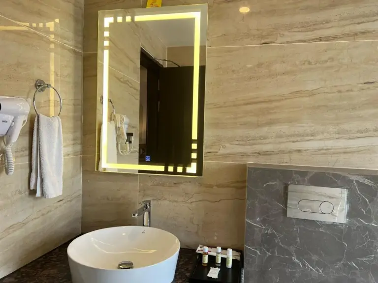 Baño moderno en Landmark Bhairahawa en Lumbini con espejo iluminado, lavabo sobre encimera y acabados de mármol