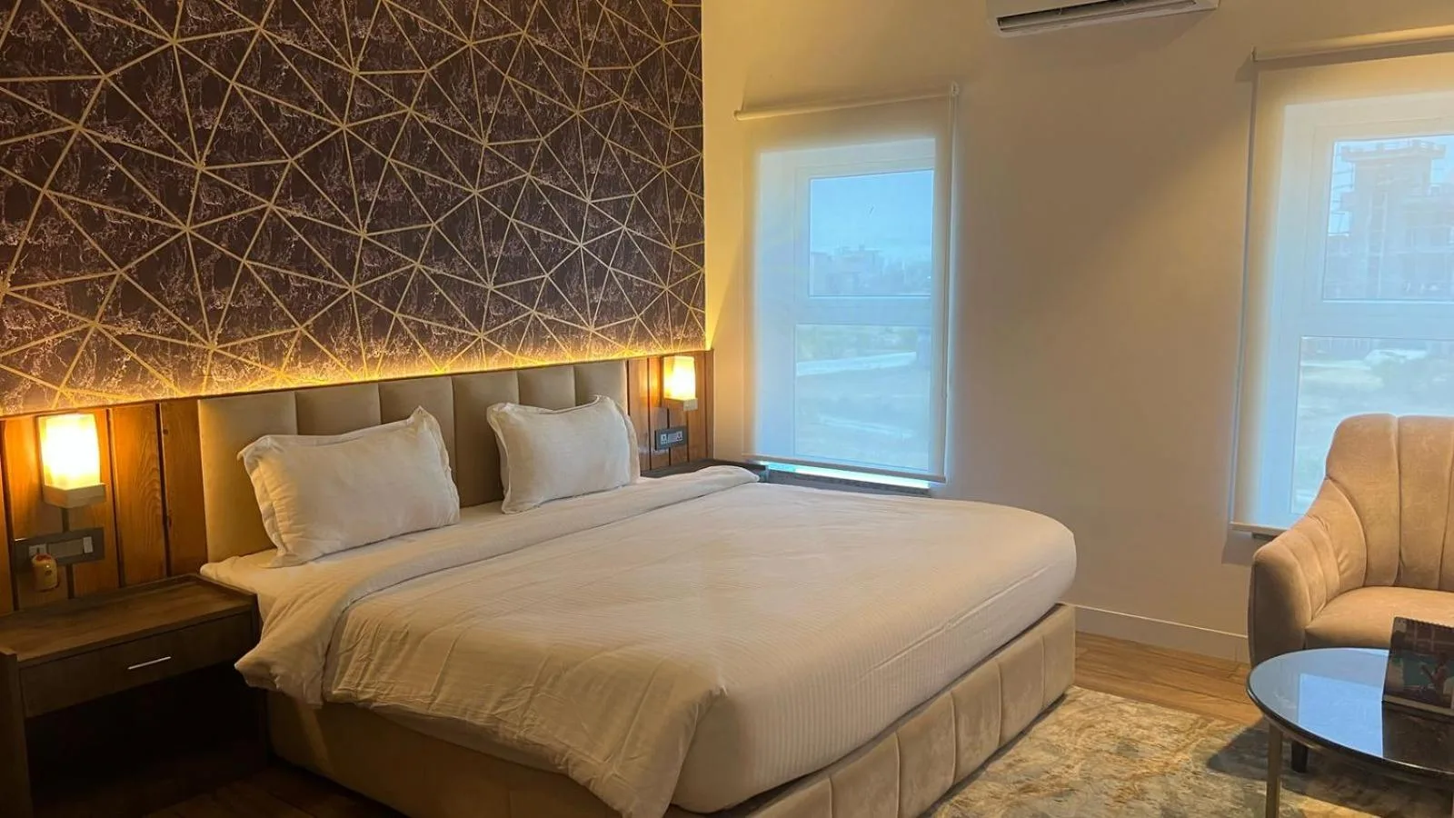 Habitación king en Landmark Bhairahawa en Lumbini con cama grande, pared de acento y zona de estar
