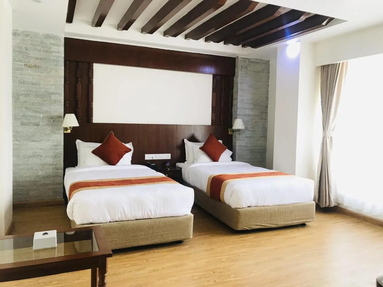Habitación doble con dos camas individuales en Landmark Pokhara en Pokhara, con un interior contemporáneo y luminoso.