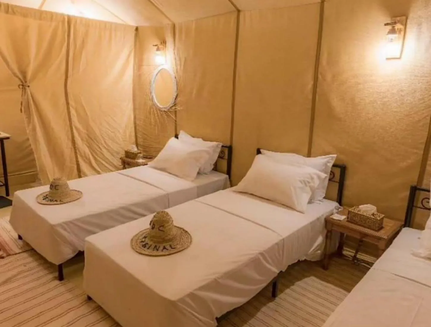 Alojamiento en tienda con varias camas en Lantern Luxury Camp en Merzouga