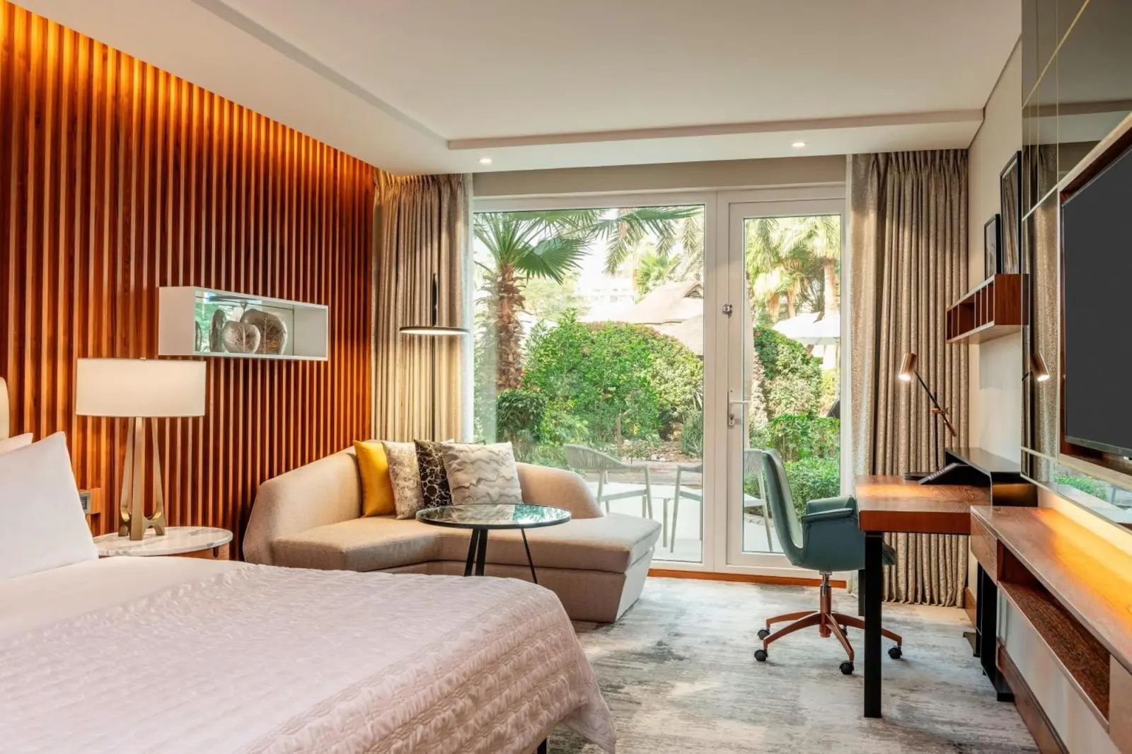 Habitación de huésped elegante en Le Méridien Dubai Hotel & Conference Centre con muebles modernos.