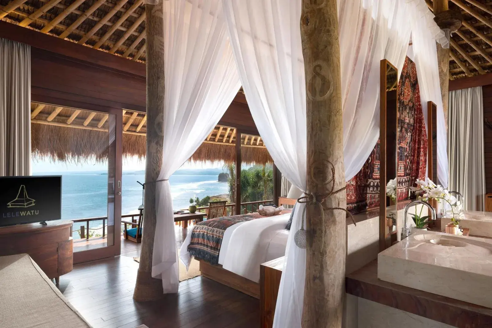Innenansicht eines Schlafzimmers im Lelewatu Resort Sumba mit Meerblick.