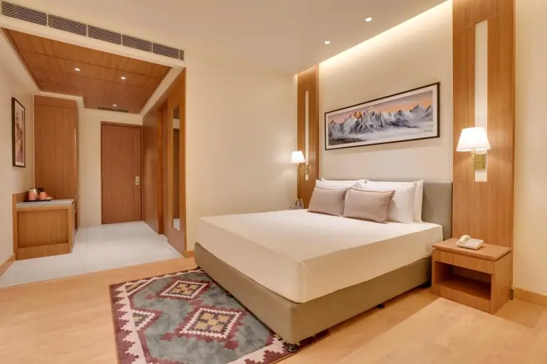 Amplia habitación king en Lemon Tree Premier, Biratnagar, Nepal con una gran cama, zona de escritorio y cálidos detalles en madera