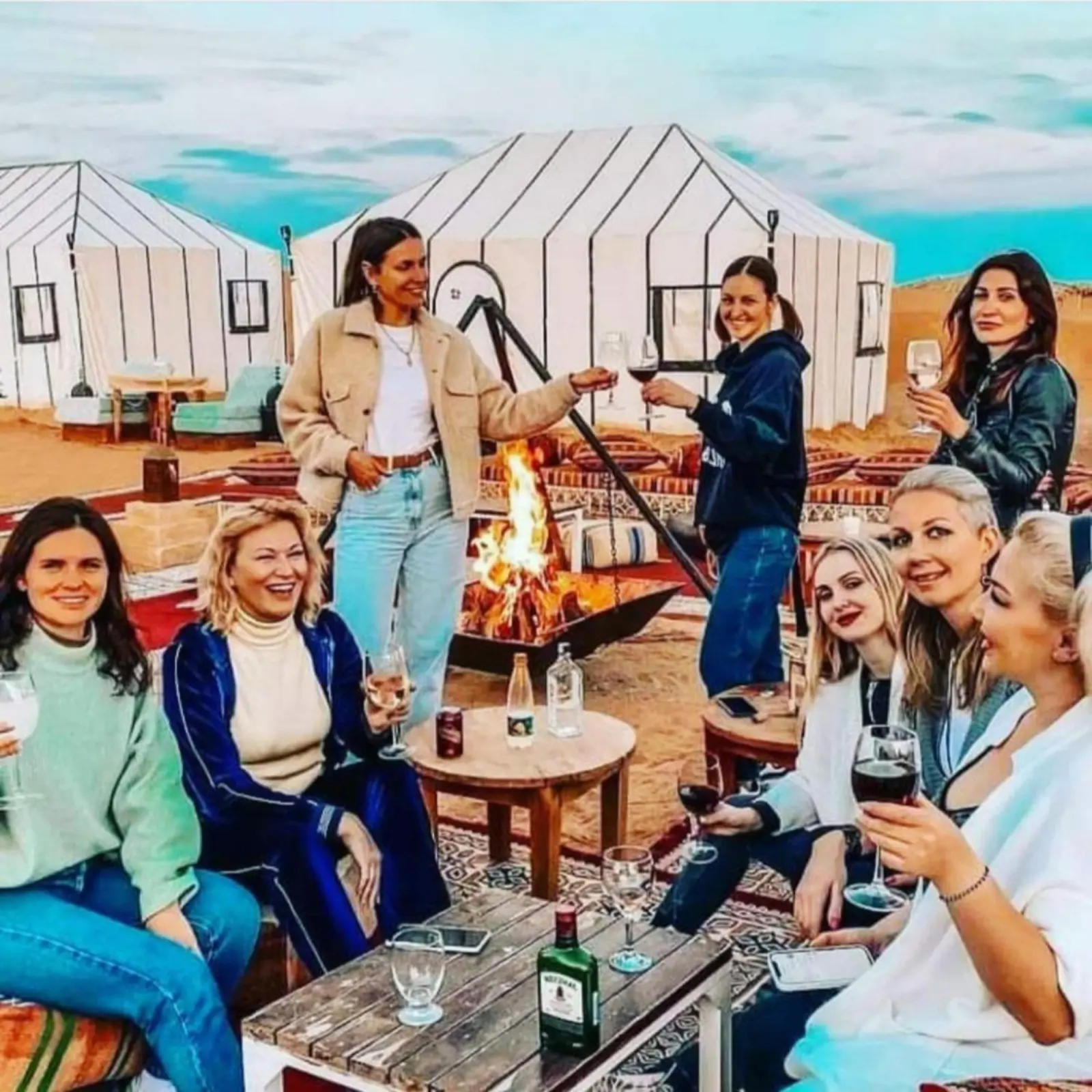 Guests enjoying campfire at Les Pyramides Luxury Desert Camp in Merzouga