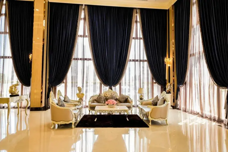 Elegante salón del vestíbulo en LK Grand Empire en Pattaya con cortinas altas y asientos ornamentados