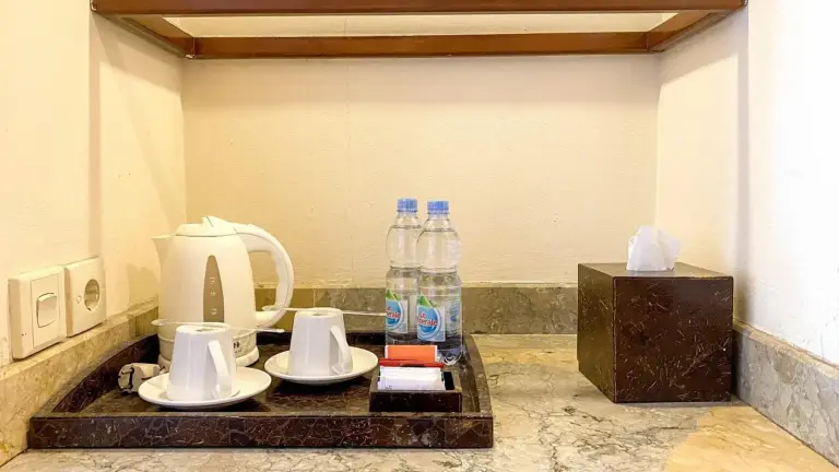 Wasserkocher, Tassen, Wasserflaschen und Taschentuchbox im Zimmer des Lorin Solo Hotel in Surakarta