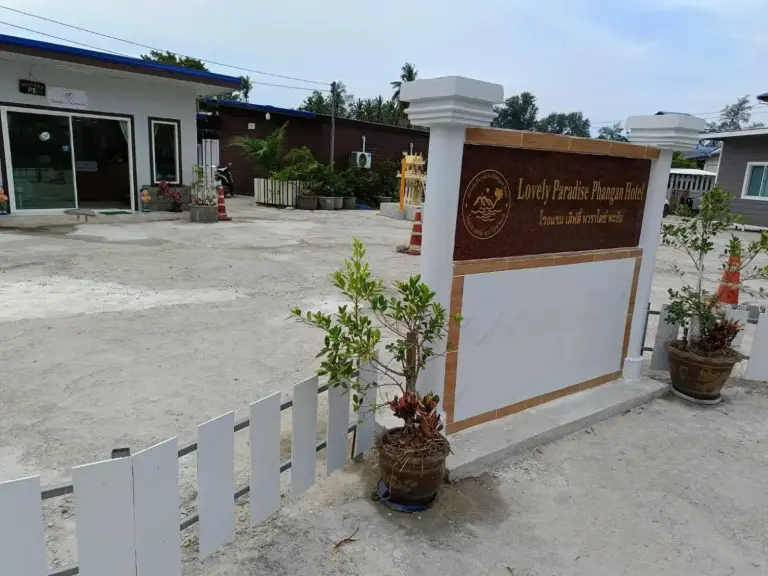 Eingangsbereich des Lovely Paradise Phangan Hotel auf Ko Pha-Ngan mit Schild, Innenhof und Gebäuden.