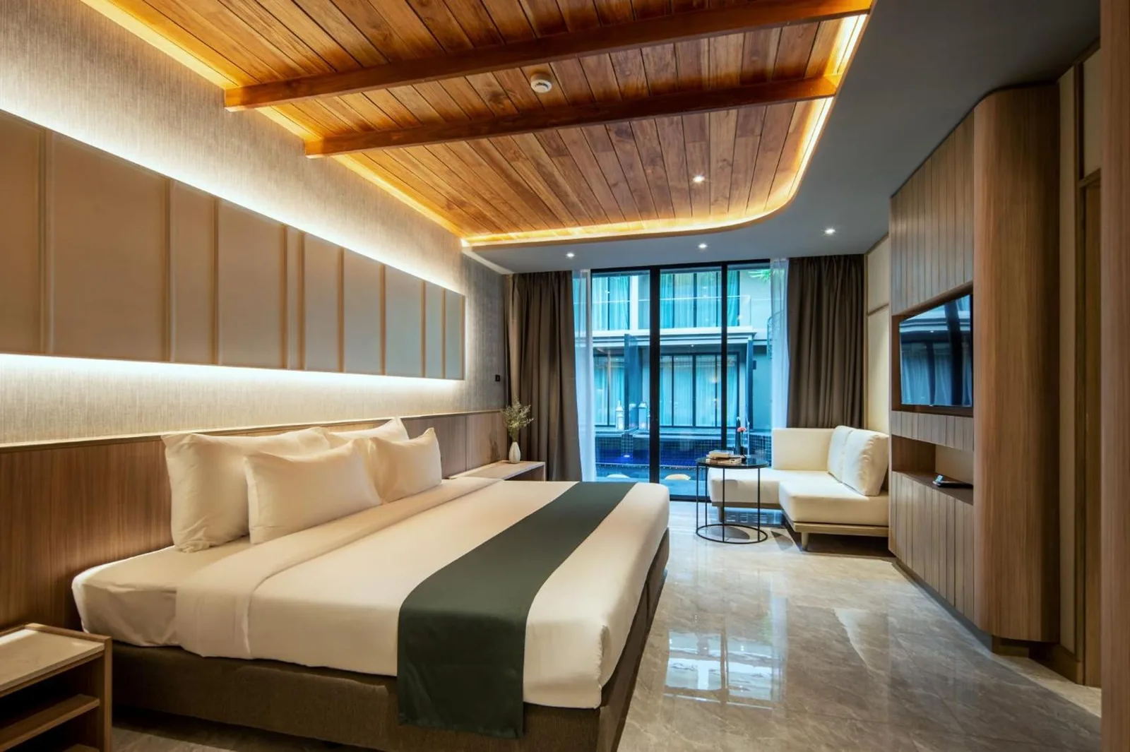 Chambre avec vue sur la piscine au Luminous Resort & Spa by Areca à Phuket avec lit king-size et coin salon face au balcon