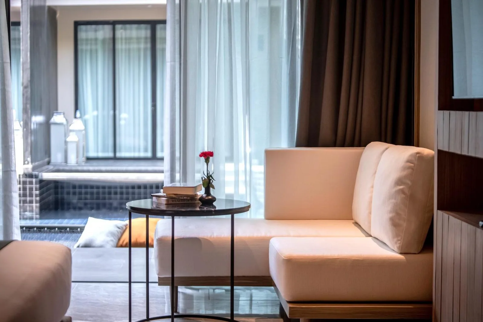 Coin salon intérieur au Luminous Resort & Spa by Areca à Phuket avec canapé et petite table près de la fenêtre