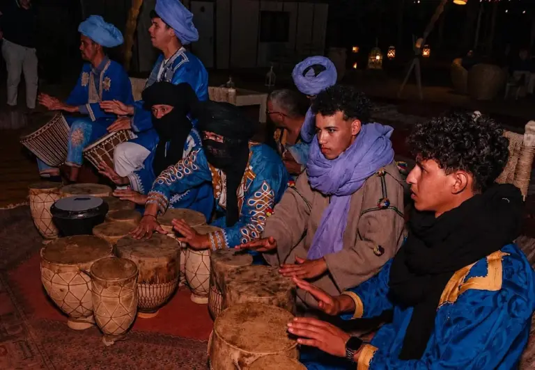 Luna Desert Luxury Camp – Merzouga, Morocco hotel – a group of people sitting around a table with baskets at Luna Desert Luxury Camp in Merzouga
