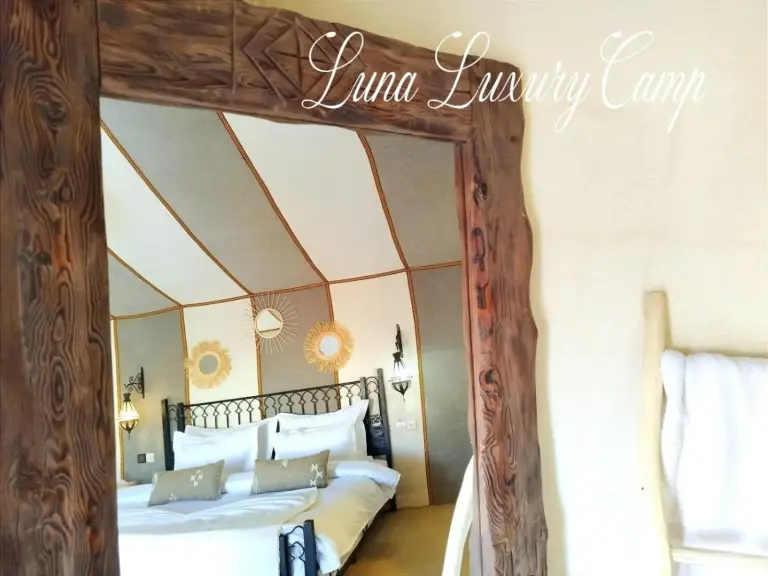 Intérieur de la salle de bains à Luna Luxury Camp Merzouga à Merzouga avec lavabo, miroir, serviettes et espace douche.