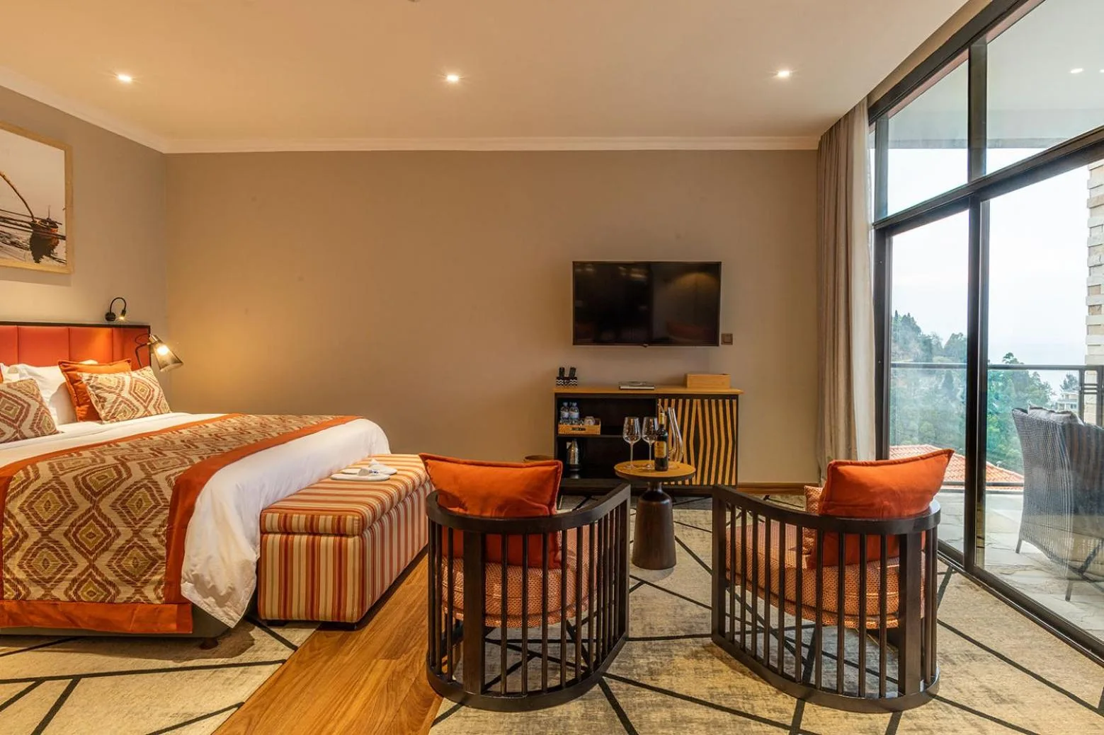 Comfortable bedroom in LUX* Lake Kivu featuring stylish decor and a view.