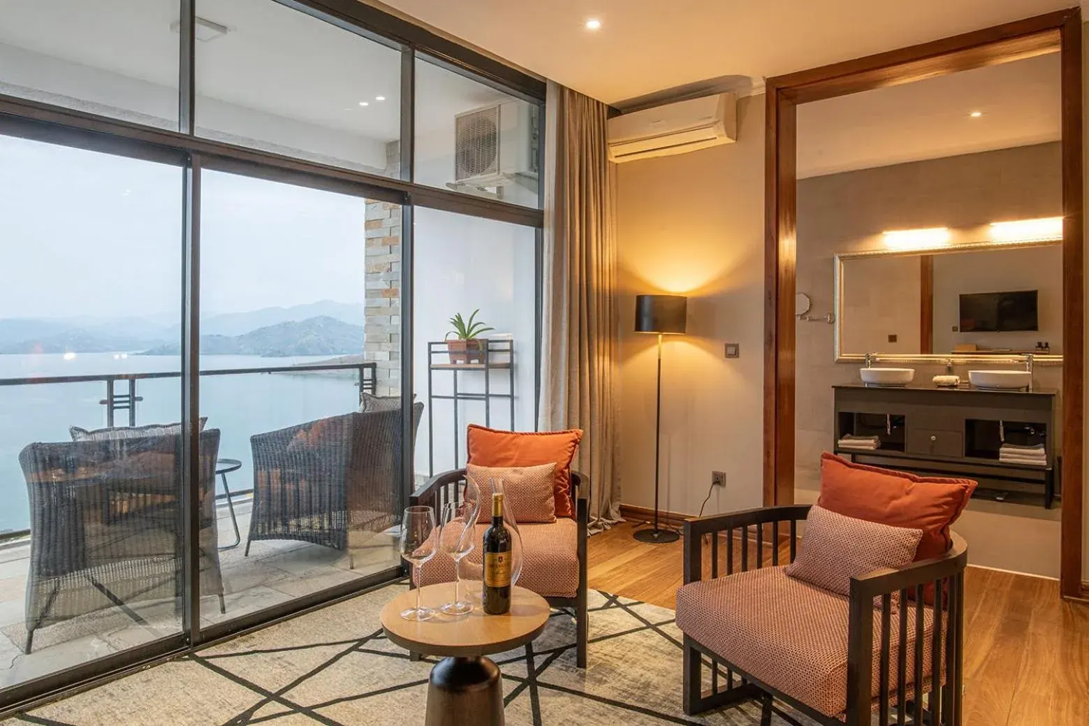 Sitting area in LUX* Lake Kivu featuring elegant chairs and a view of the lake.