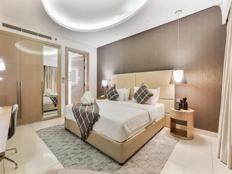 Luxury 1BR bedroom with comfortable bedding and city view.