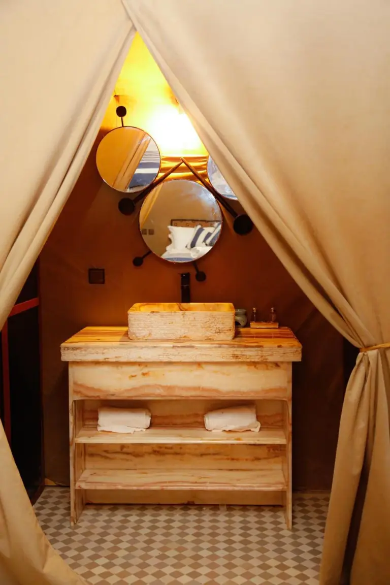 Luxury berber style in Merzouga bathroom vanity with rustic wood sink and round mirrors