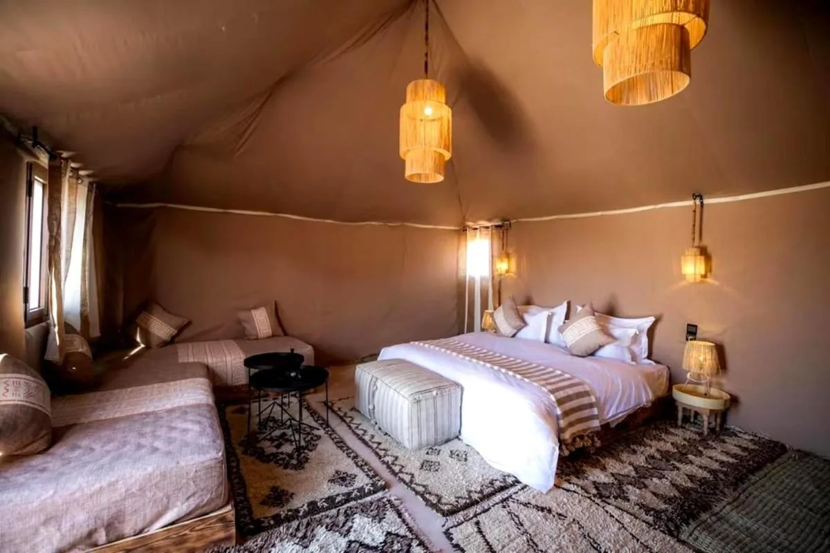 Luxury Camp Plus Activities in Merzouga family-style tent room with sofa and bed