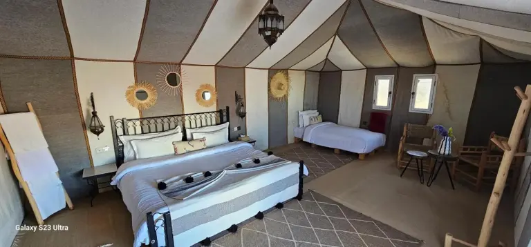 Family tent room at Luxury Nomadic Tented Camp in Merzouga with multiple beds and warm traditional styling.