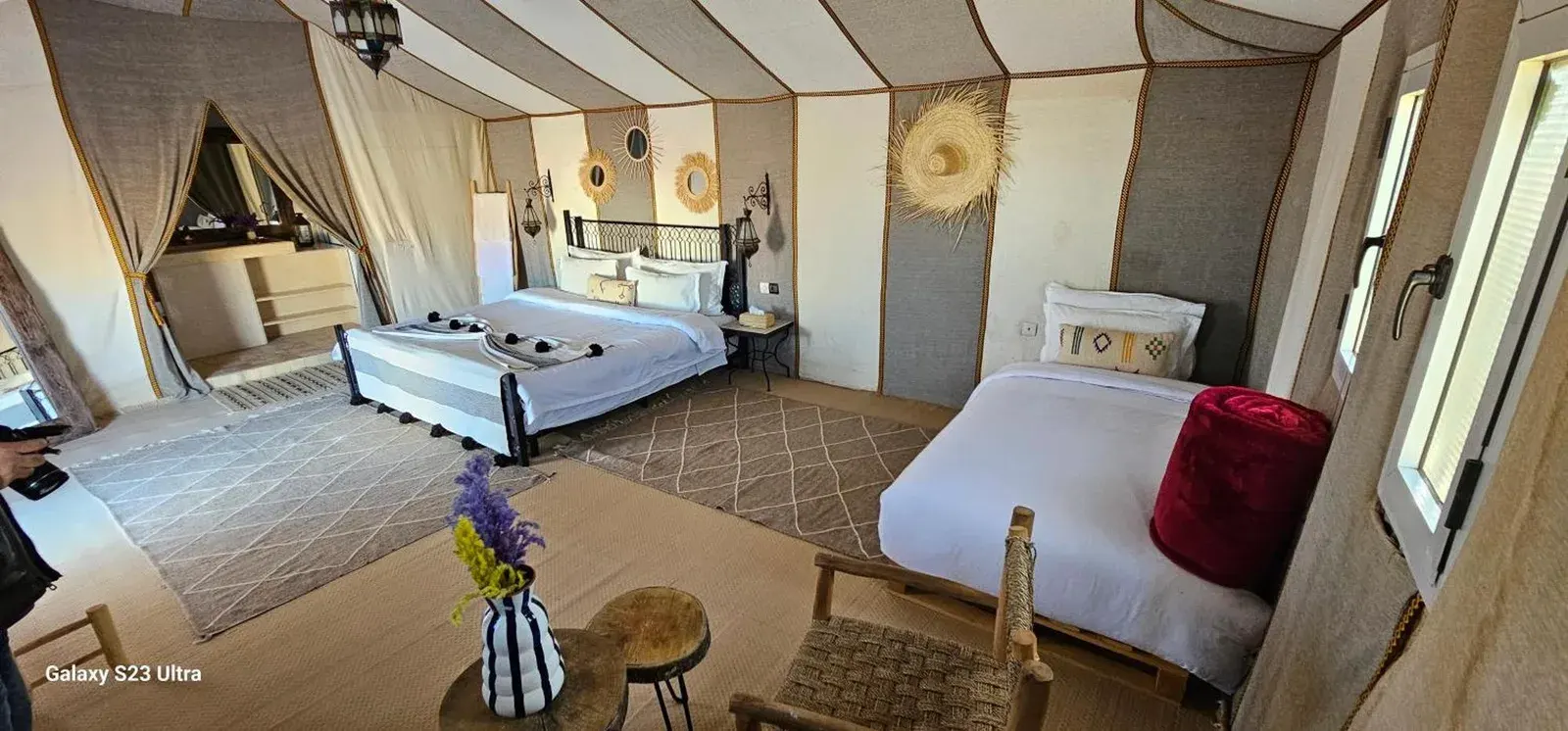 Triple suite tent at Luxury Nomadic Tented Camp in Merzouga with three beds and desert lodge decor.