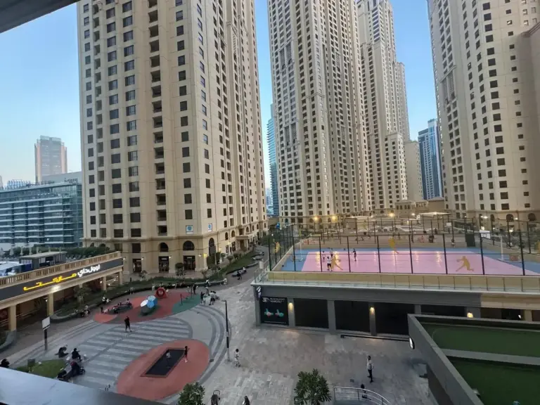 Patio y zona deportiva cerca de Magic JBR & Dubai Marina en Dubai, rodeados de altas torres de apartamentos.