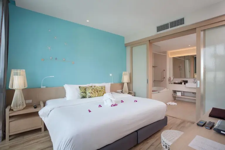 Bright bedroom at Mai Khaolak Beach Resort & Spa - TUIBLUE Mai Khaolak with king bed and turquoise feature wall.