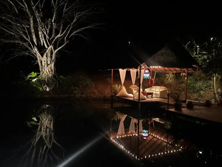 Vista nocturna de la zona de estar con luces en Maia Residence Pai
