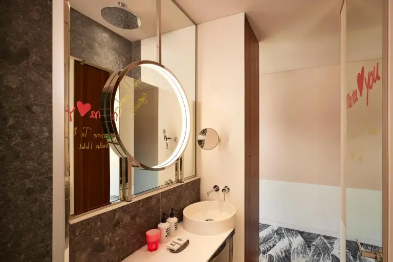 Bathroom at Mama Shelter Dubai with sink, mirror, and shower area