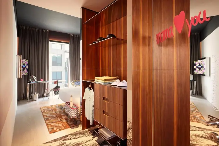 Wardrobe and bedroom corner in Mama Shelter Dubai with playful wall branding