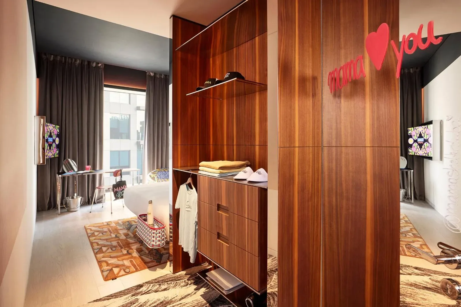 Wardrobe and bedroom corner in Mama Shelter Dubai with playful wall branding