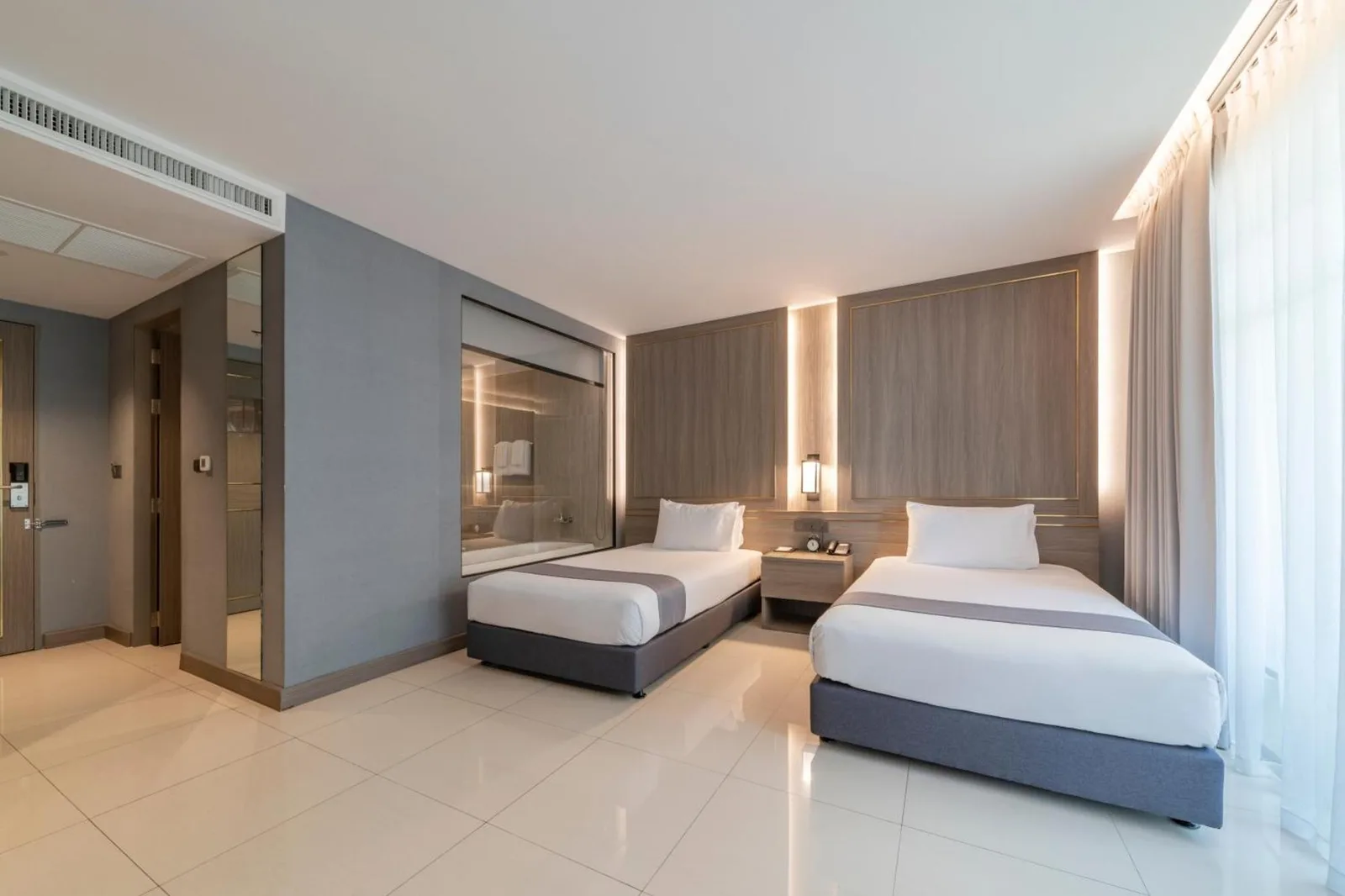 Twin guest room at Mandarin Eastville, Pattaya - SHA Extra Plus with two single beds, large windows, and modern decor.