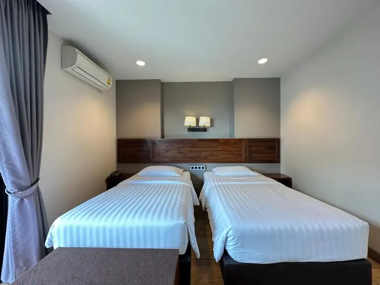 Twin bed room at Mangrove Prestige Hotel in Pattaya with air conditioning and wood headboard