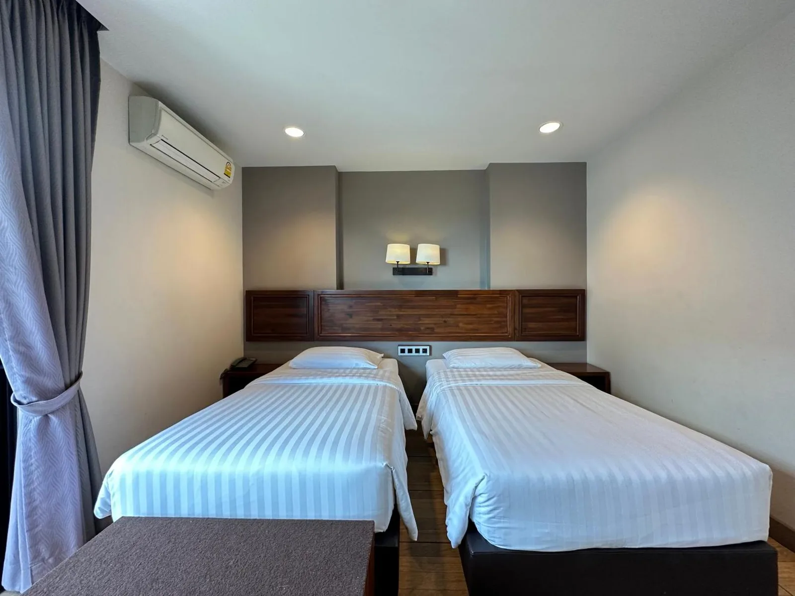 Twin bed room at Mangrove Prestige Hotel in Pattaya with air conditioning and wood headboard
